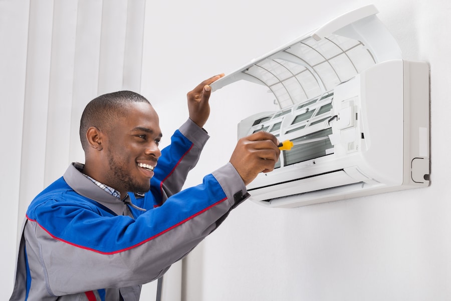 black-technician-fixing-ductless-AC